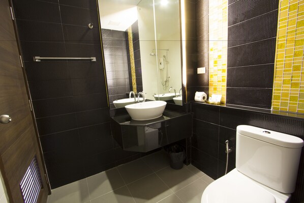 A modern bathroom with a glass shower enclosure, a white sink, and a toilet. - Siva Royal Hotel (Phatthalung)