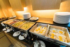 A buffet with various food options including fried eggs, rice dishes, and other prepared meals. - Siva Royal Hotel (Phatthalung)