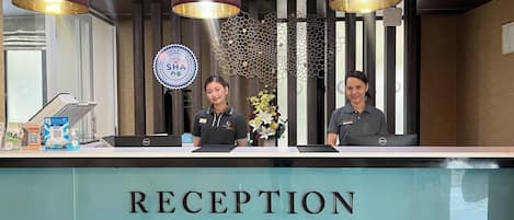 Un área de recepción con un letrero que dice "RECEPTION" y el logotipo de "SHA".