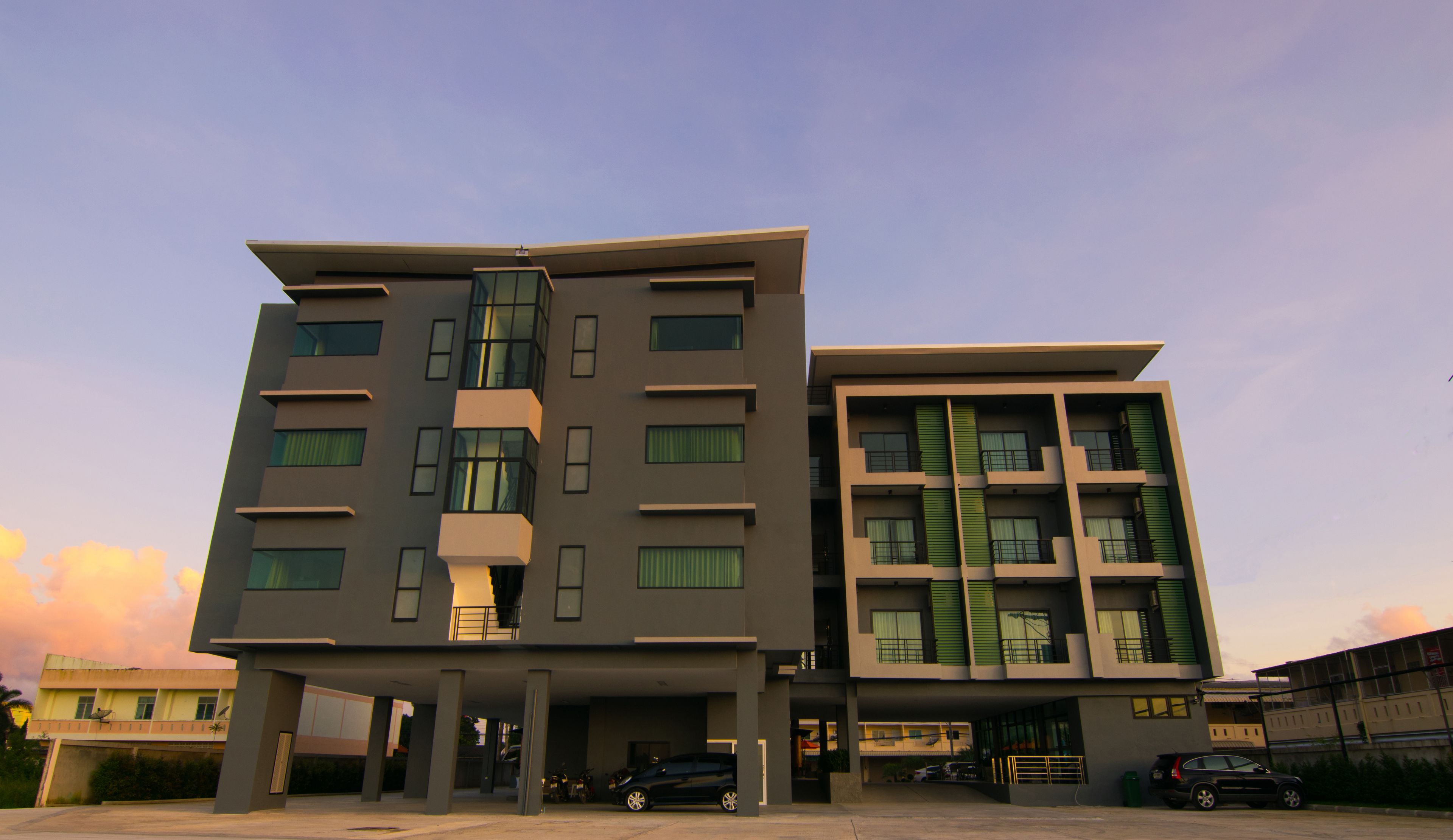 A modern multi-story building with a flat roof and large windows.