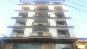 Un hôtel à plusieurs étages, avec des balcons à chaque niveau.