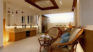 Un interior moderno con una zona de bar, muebles de mimbre y un ventanal grande.