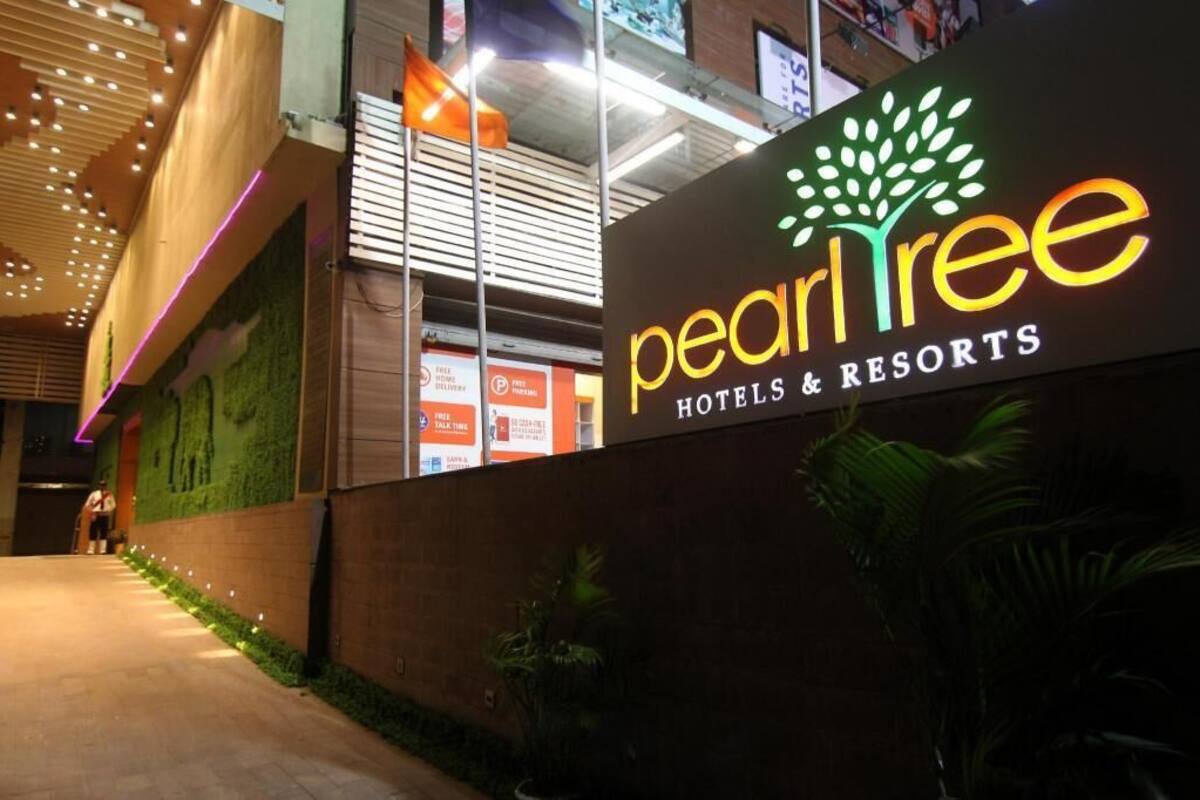 A sign for 'pearl tree hotels & resorts' with a logo featuring a tree.
