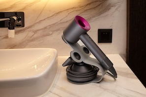A bathroom with a white bathtub, a modern faucet, and a hair dryer mounted on a marble countertop. - Mercure Yangzhou Dongguan Street (Yangzhou)