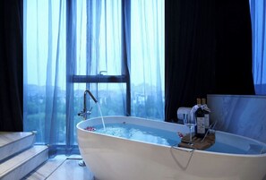 A modern bathroom with a freestanding bathtub, a window with sheer curtains, and a view of the cityscape. - Mercure Yangzhou Dongguan Street (Yangzhou)