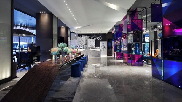 Un intérieur moderne comprenant un comptoir d’accueil, un espace détente et un bar.
