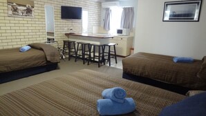 A room with two beds, a small kitchenette, a TV, and a window. - Goomeri Motel (Goomeri)