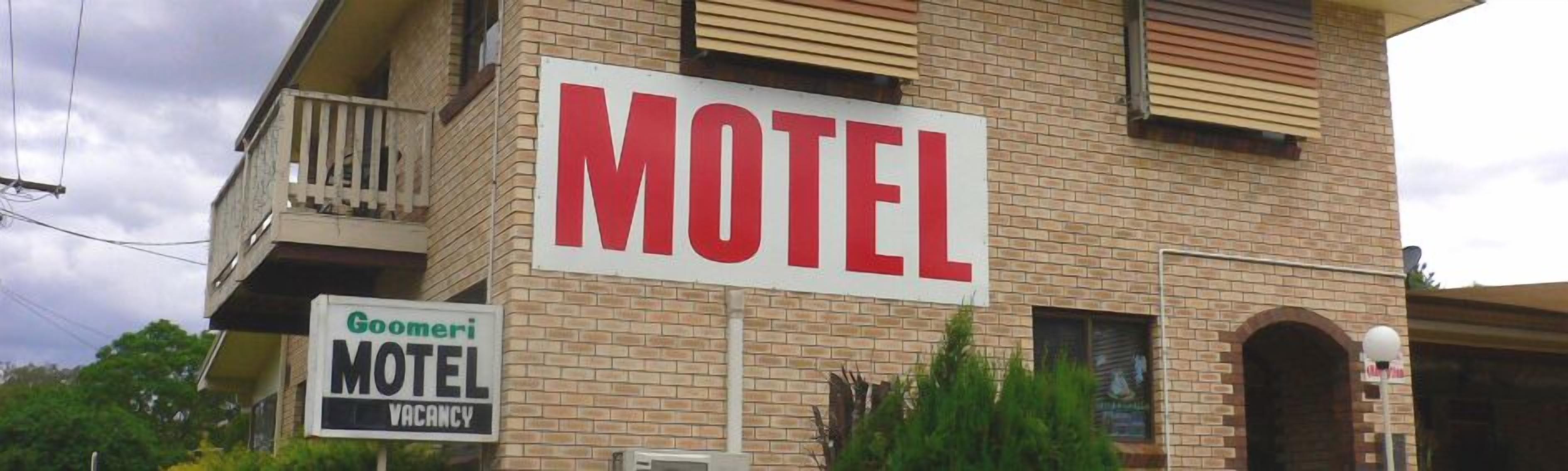 Ein Schild eines Motels mit dem Wort 'MOTEL' in großen, roten Buchstaben.