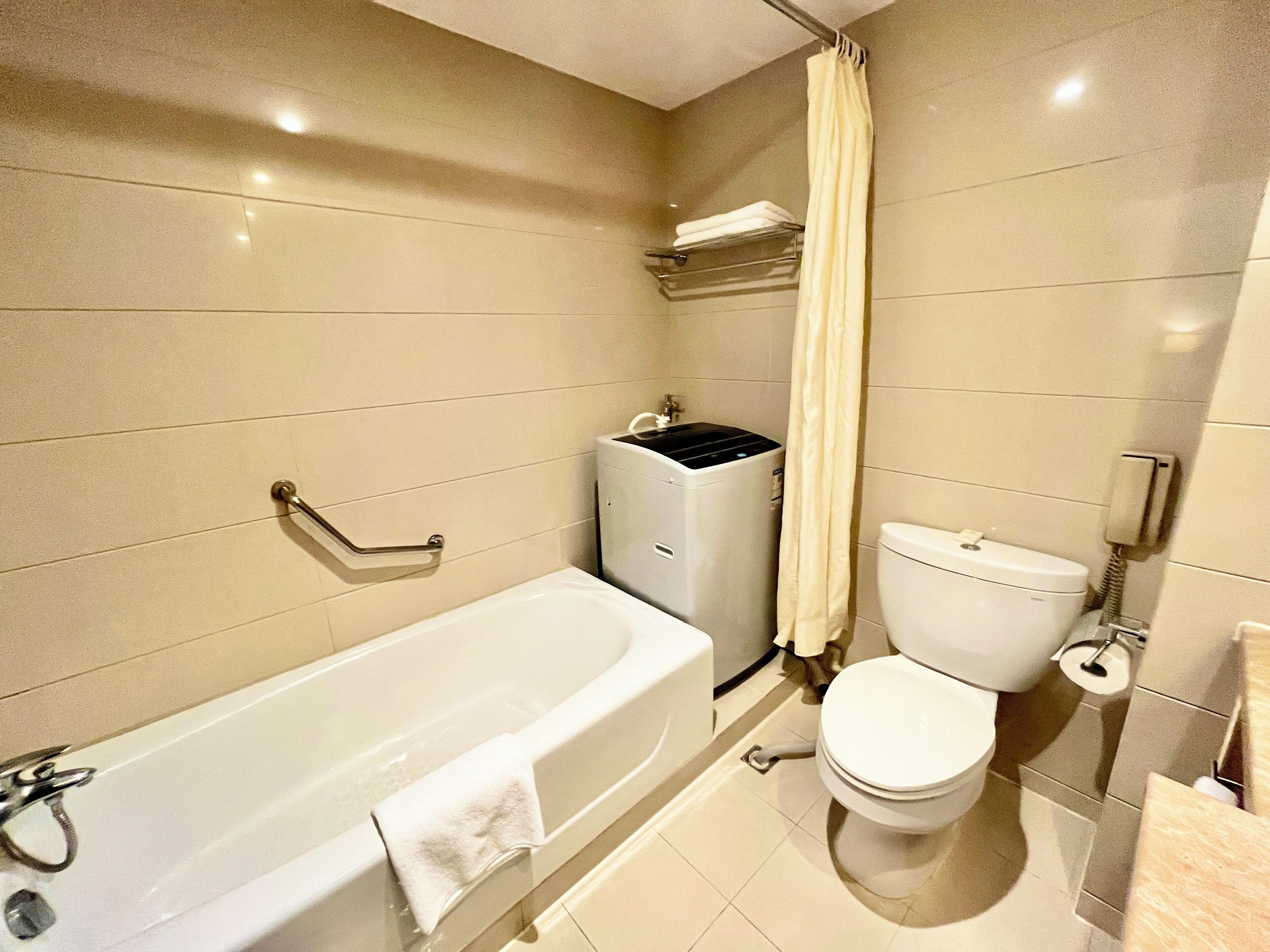 A bathroom with a bathtub, toilet, and a shower curtain.