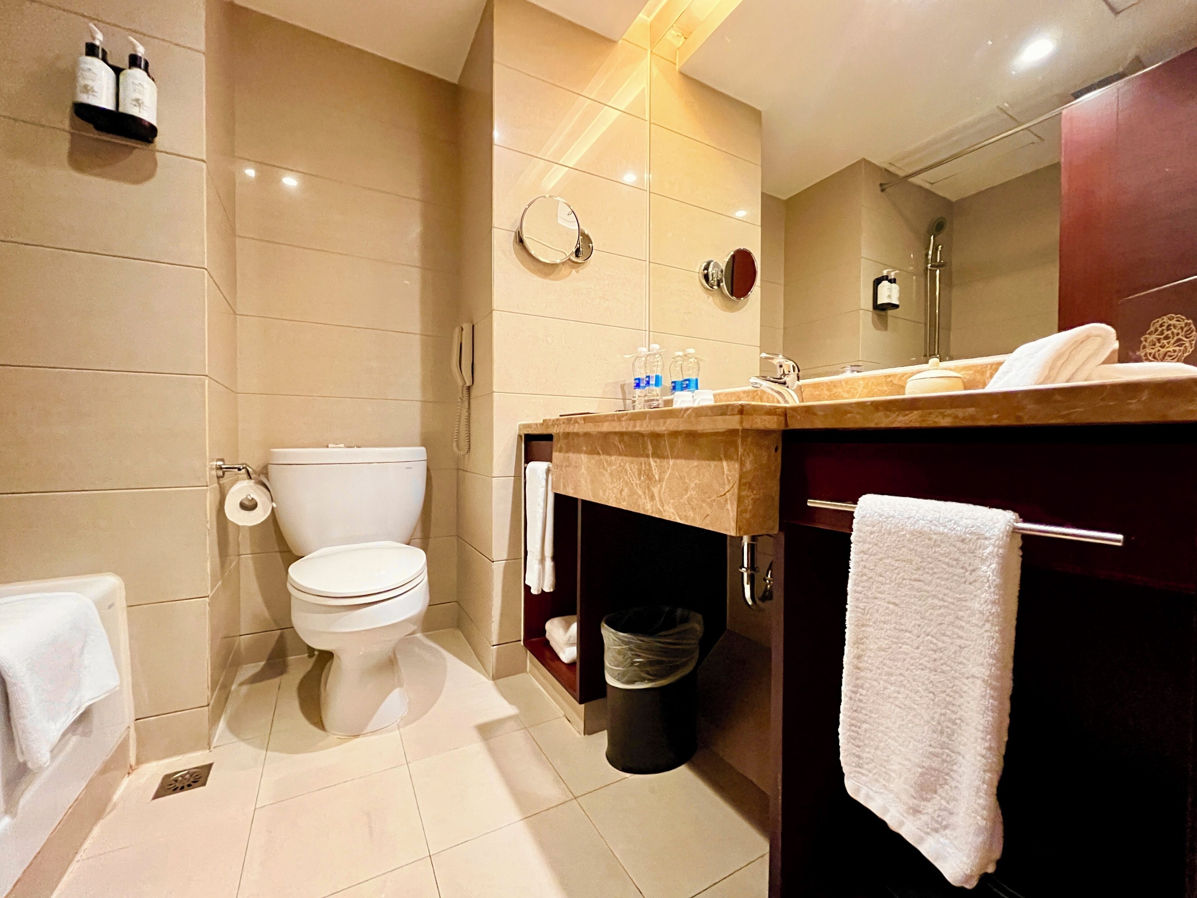 Un baño moderno con inodoro, lavamanos y espejo.