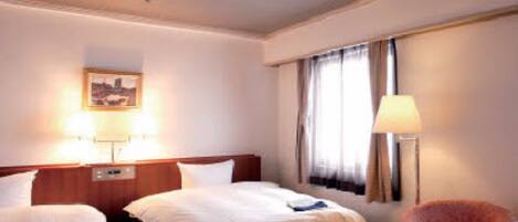 A hotel room with two beds, a desk, a chair, a lamp, and a painting on the wall.