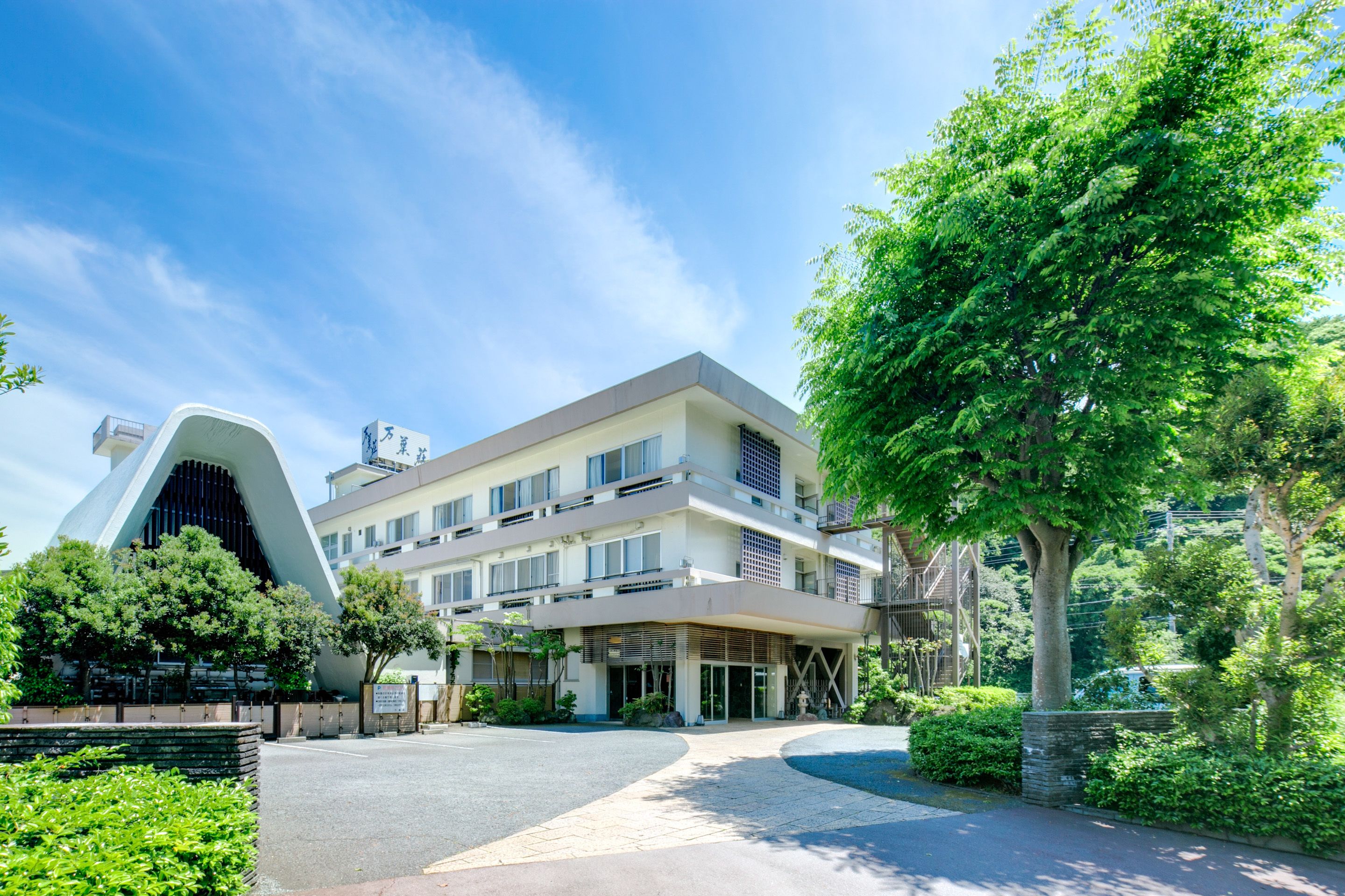 A modern building with a unique architectural design, featuring a curved facade and multiple balconies.