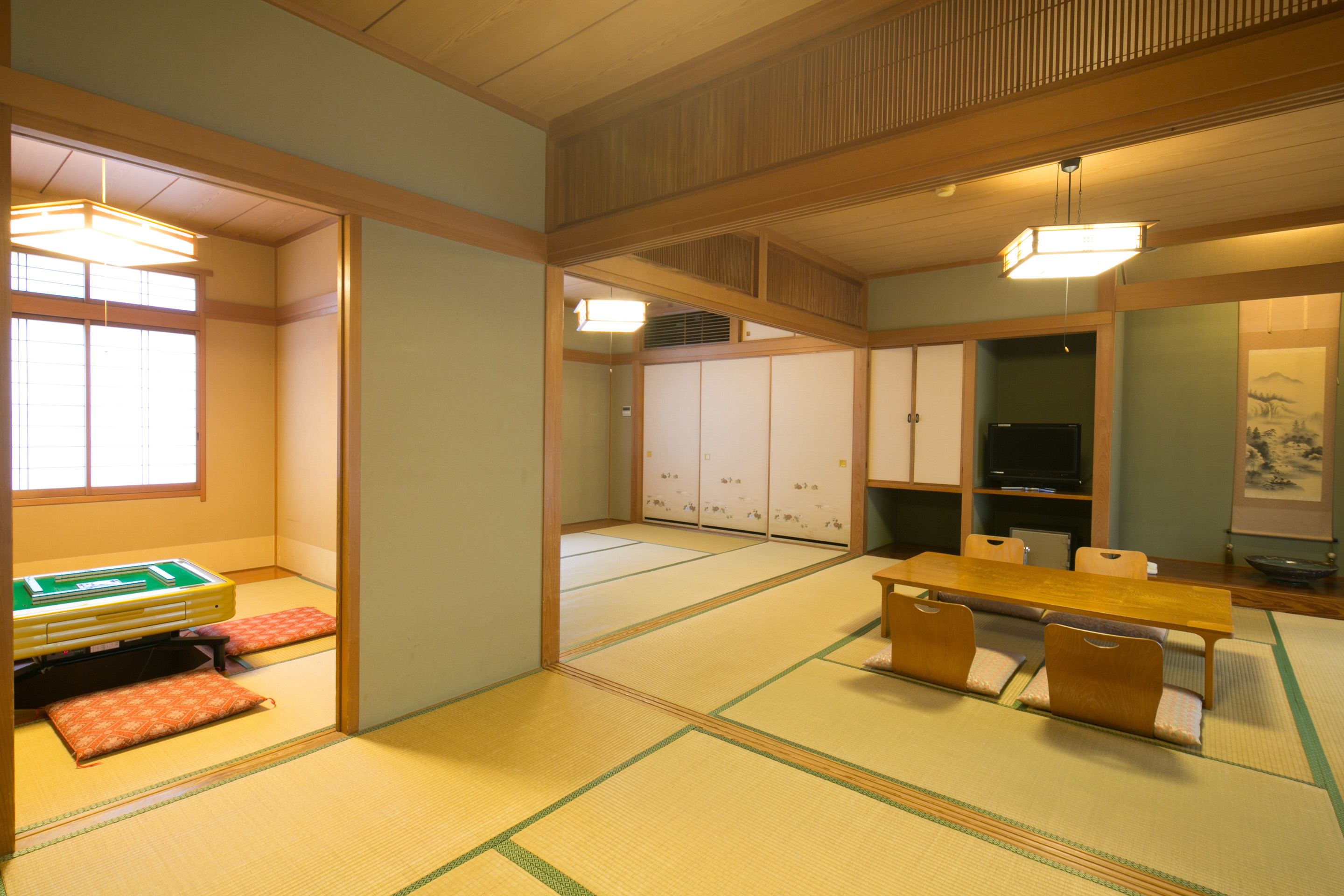 A traditional Japanese room with tatami flooring, a low wooden table, and a futon bed.