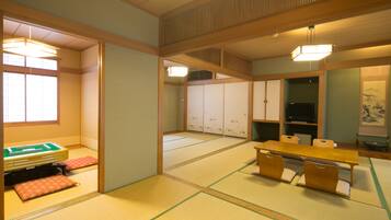 A traditional Japanese room with tatami flooring, a low wooden table, and a futon bed.
