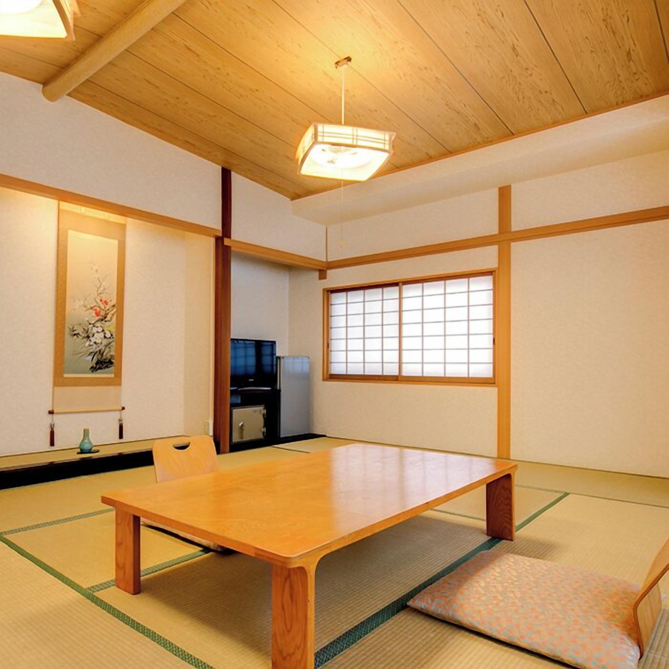 A traditional Japanese room with tatami flooring, a low wooden table, a sliding door, and a view through a shoji screen.