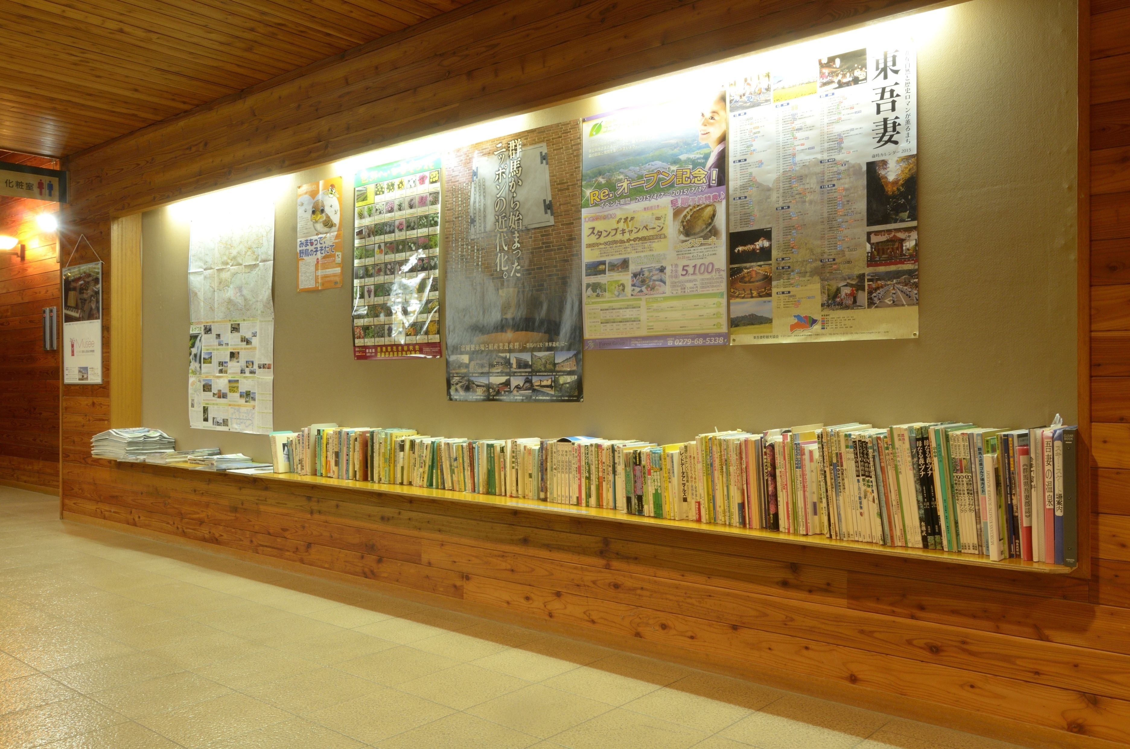 A library with wooden bookshelves and informational posters on the wall.