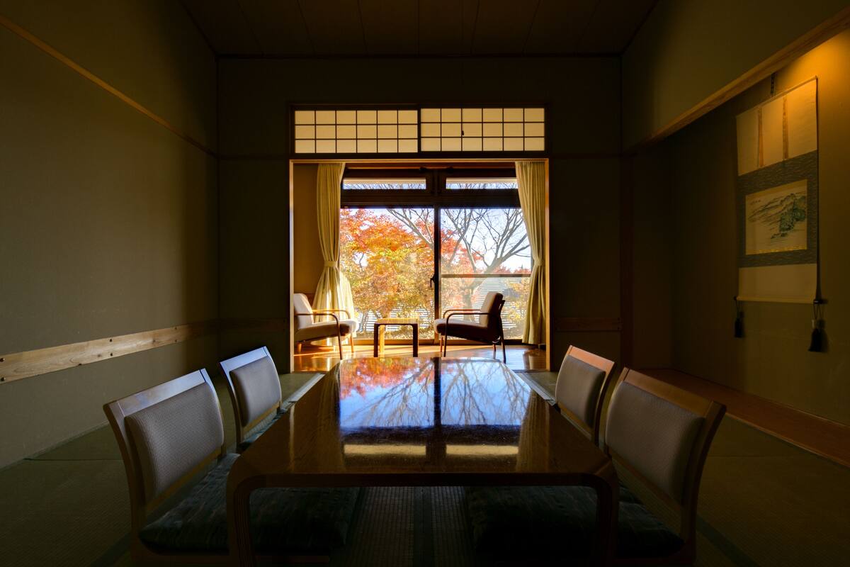 A traditional Japanese-style room with tatami flooring, a low table, and shoji screens.