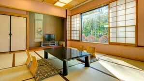 Una habitación japonesa tradicional con suelo de tatami, una mesa baja y puertas correderas.