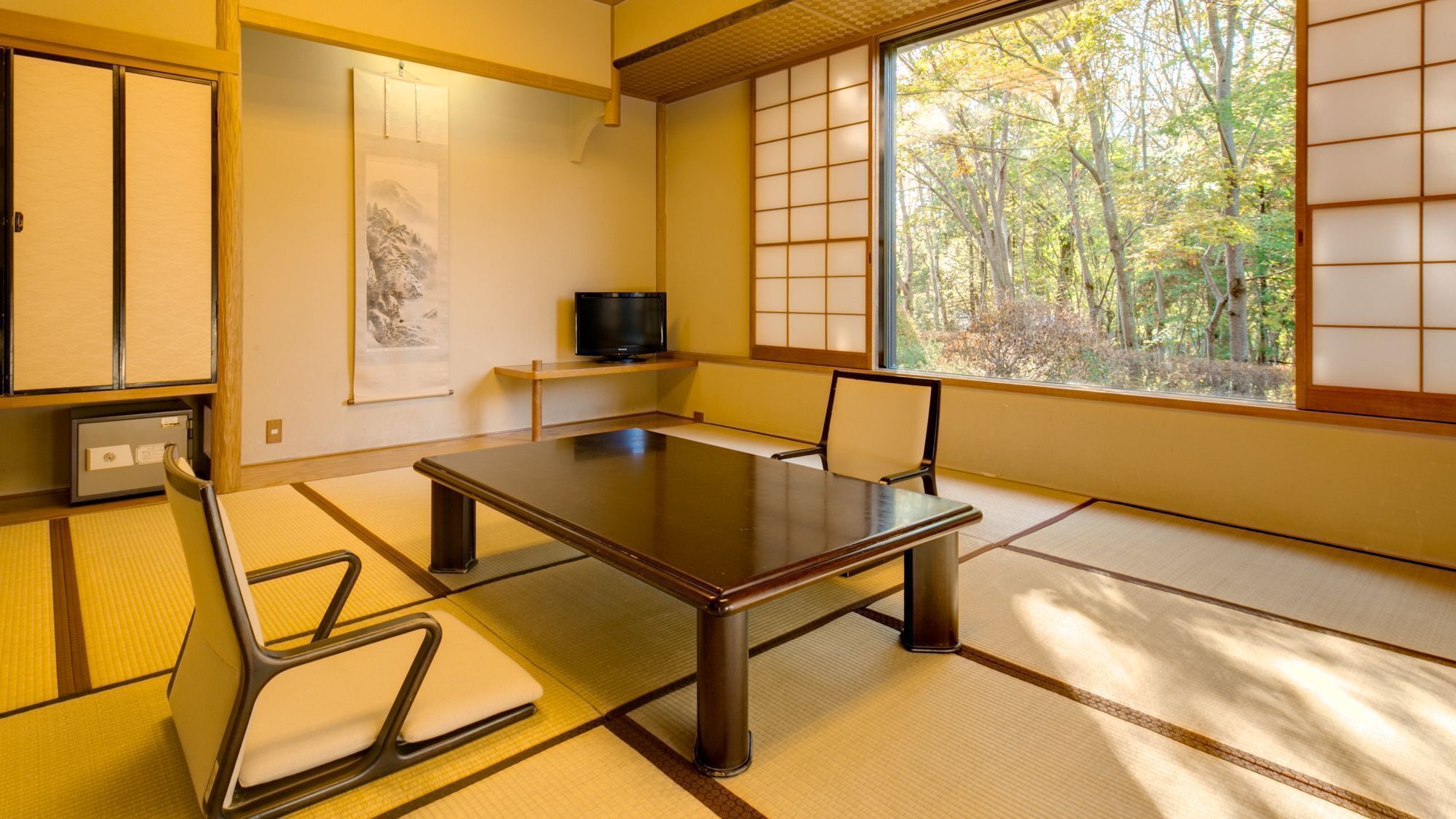 A traditional Japanese-style room with tatami flooring, a low table, and shoji screens.