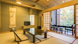 Una habitación japonesa tradicional con suelo de tatami, una mesa baja y paneles shoji.