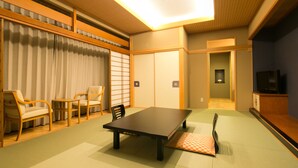 A traditional Japanese room with tatami flooring, a low table, and wooden chairs. - Yugawara Mizunokaori (Yugawara)