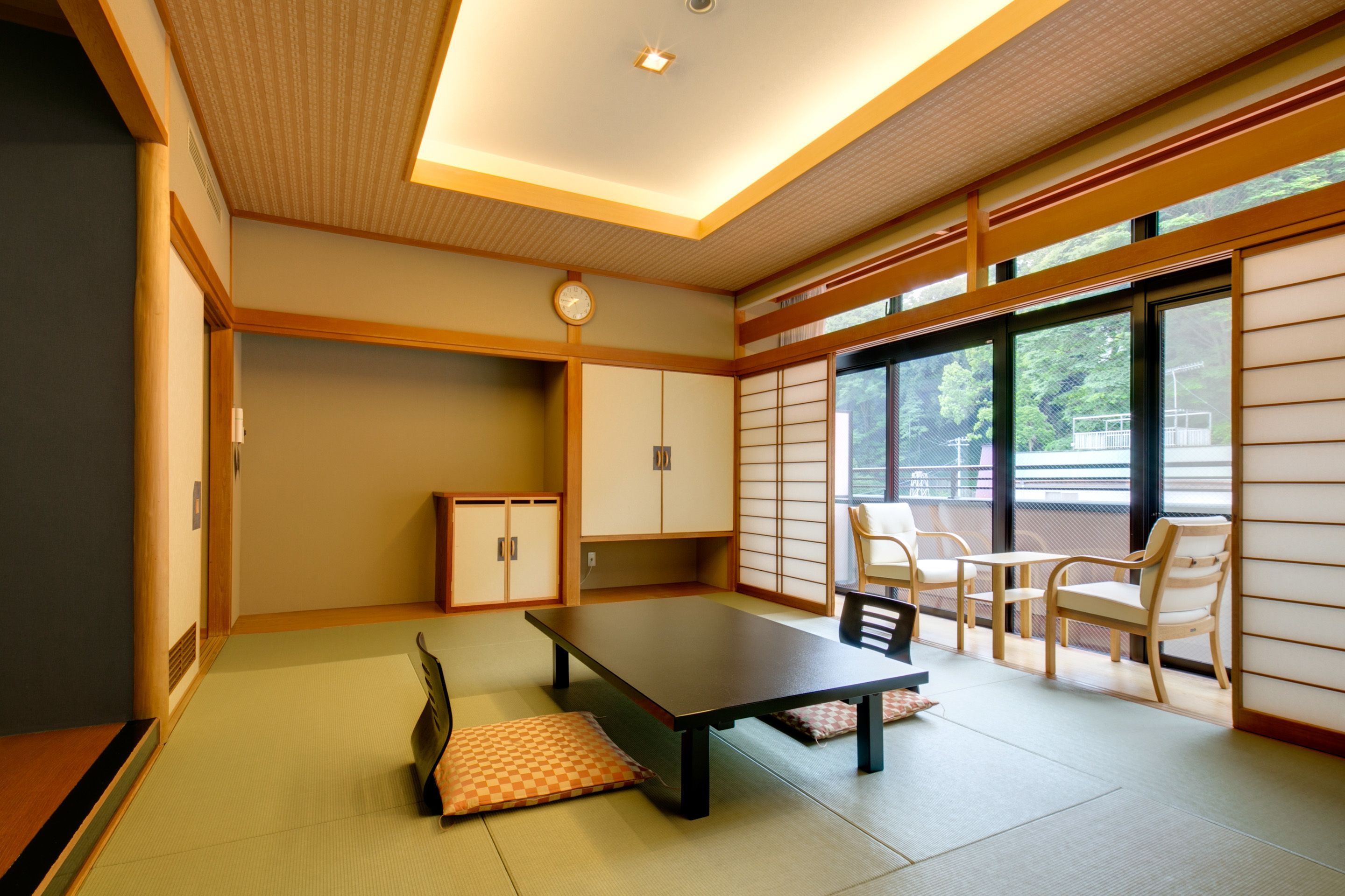 A traditional Japanese room with tatami flooring, a low table, and sliding doors.