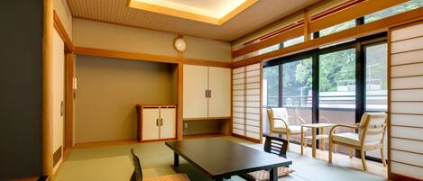 A traditional Japanese room with tatami flooring, a low table, and sliding doors.