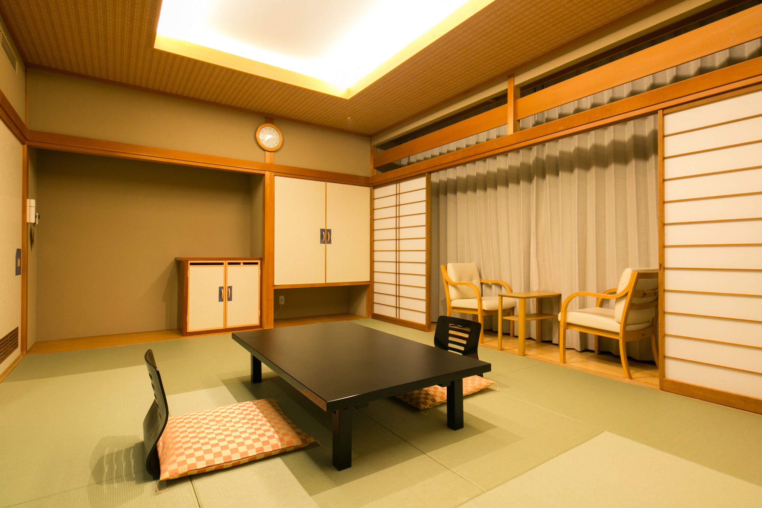 Une pièce de style japonais traditionnel, avec un sol recouvert de tatamis, une table basse et des portes coulissantes.
