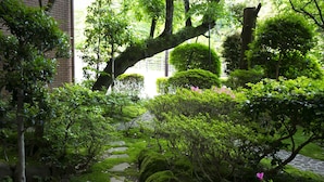 A garden with stone paths, moss-covered rocks, and various shrubs. - Yugawara Mizunokaori (Yugawara)