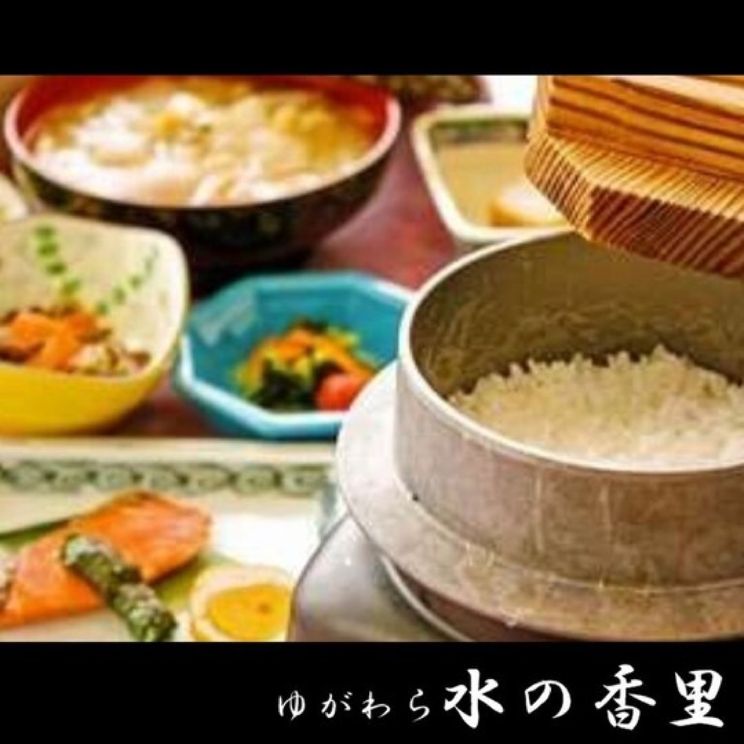 A traditional Japanese meal with various dishes including rice, sashimi, and vegetables.