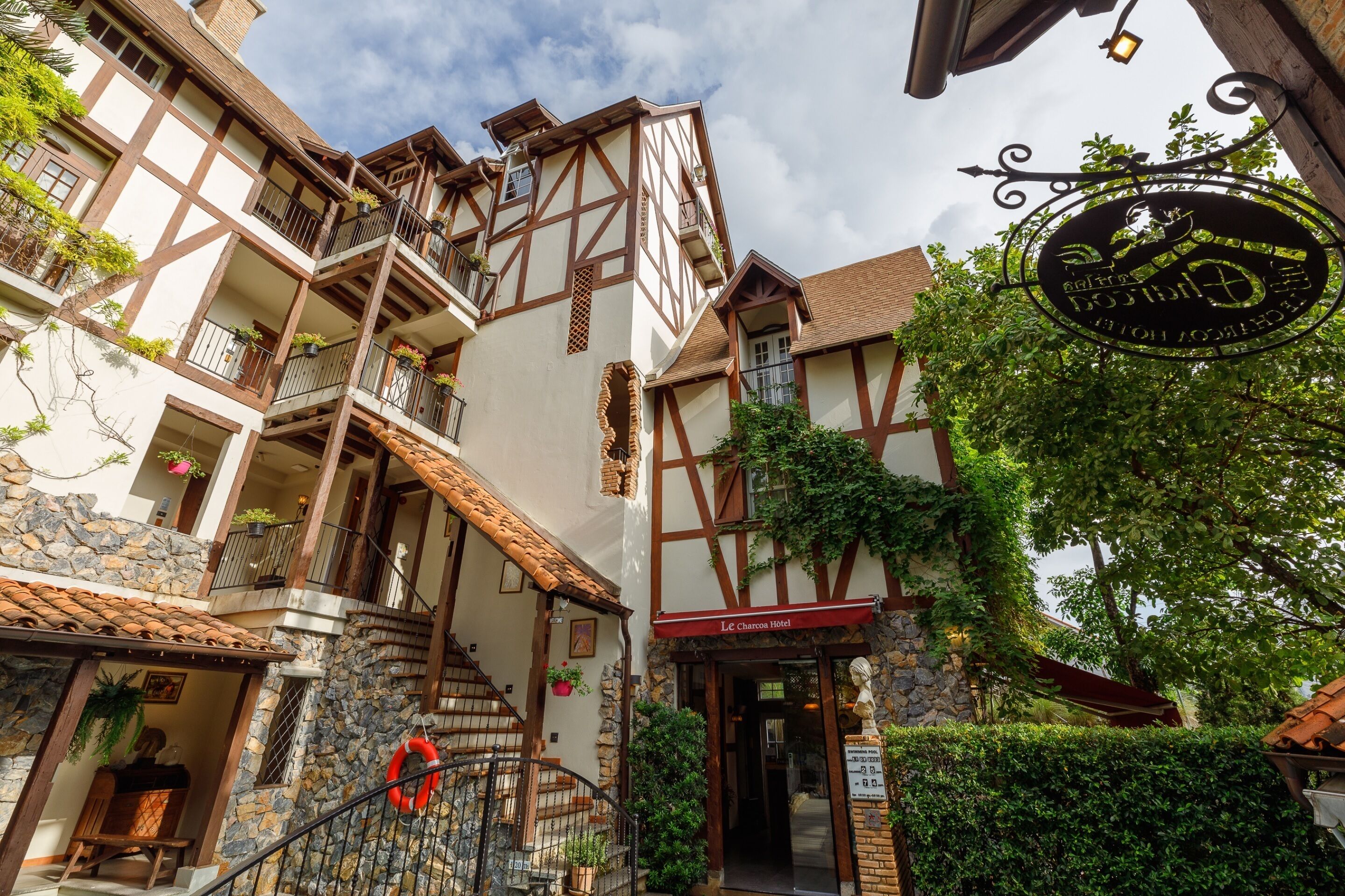 Un bâtiment de style européen traditionnel, avec une façade en pierre, de nombreux balcons et une enseigne indiquant qu’il s’agit d’un hôtel.
