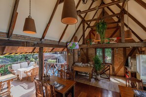 Un comedor rústico con muebles de madera, lámparas colgantes y una pared de ladrillo.