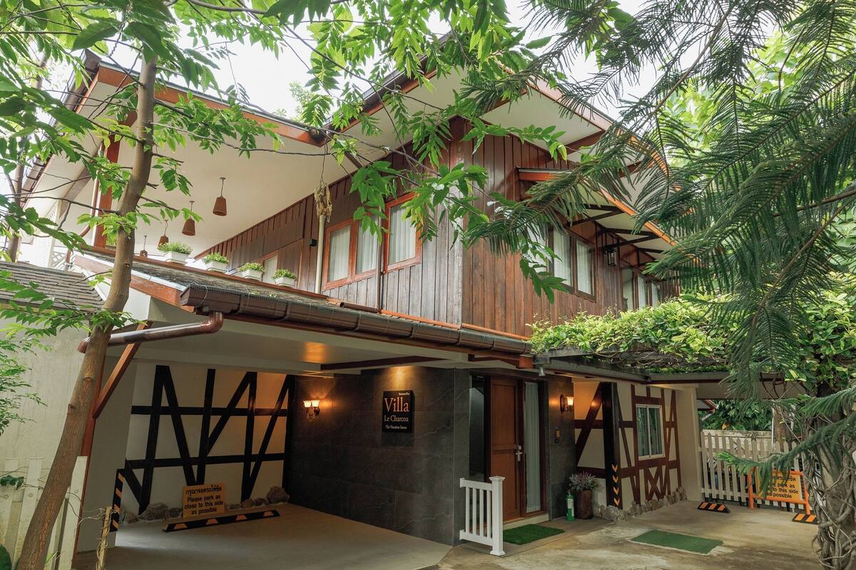A villa with a wooden facade, a sign reading "Villa Le Chasseur," and a small porch area.