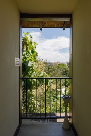 Un balcón con vistas a zonas verdes y edificios.