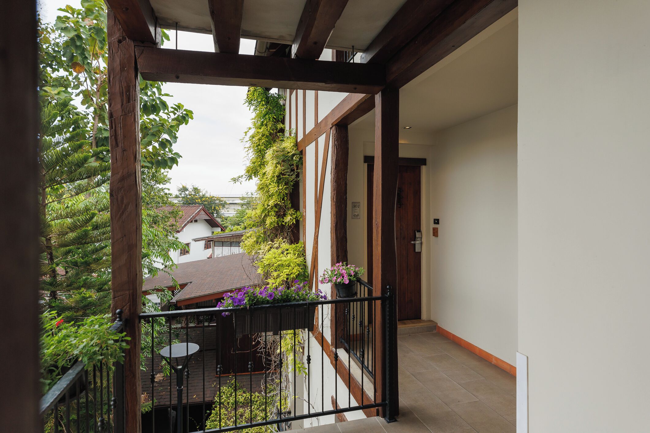 Un balcon donnant sur un jardin et les bâtiments voisins.