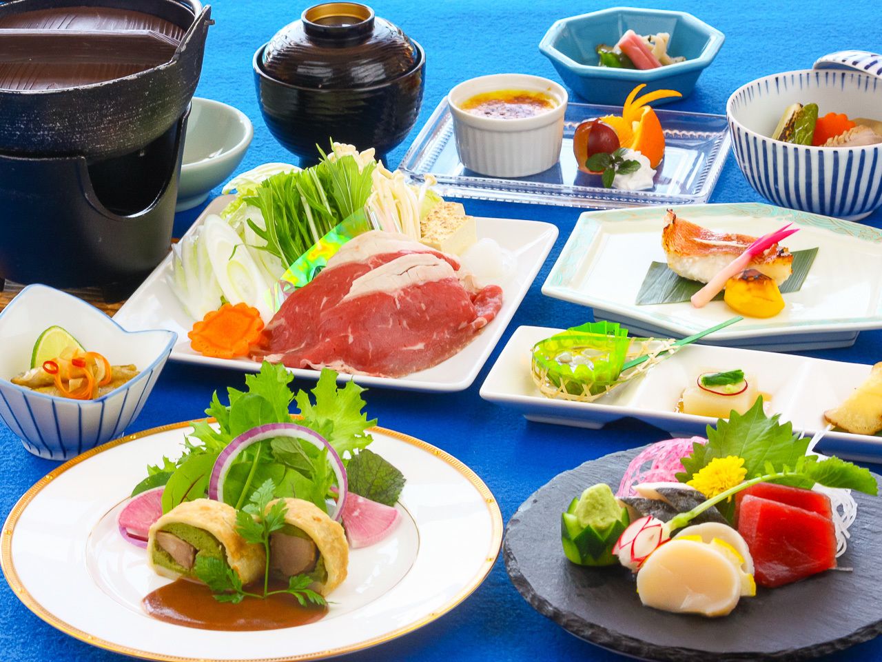 A variety of dishes and food items on a table, including plates of meat, vegetables, and other food preparations.