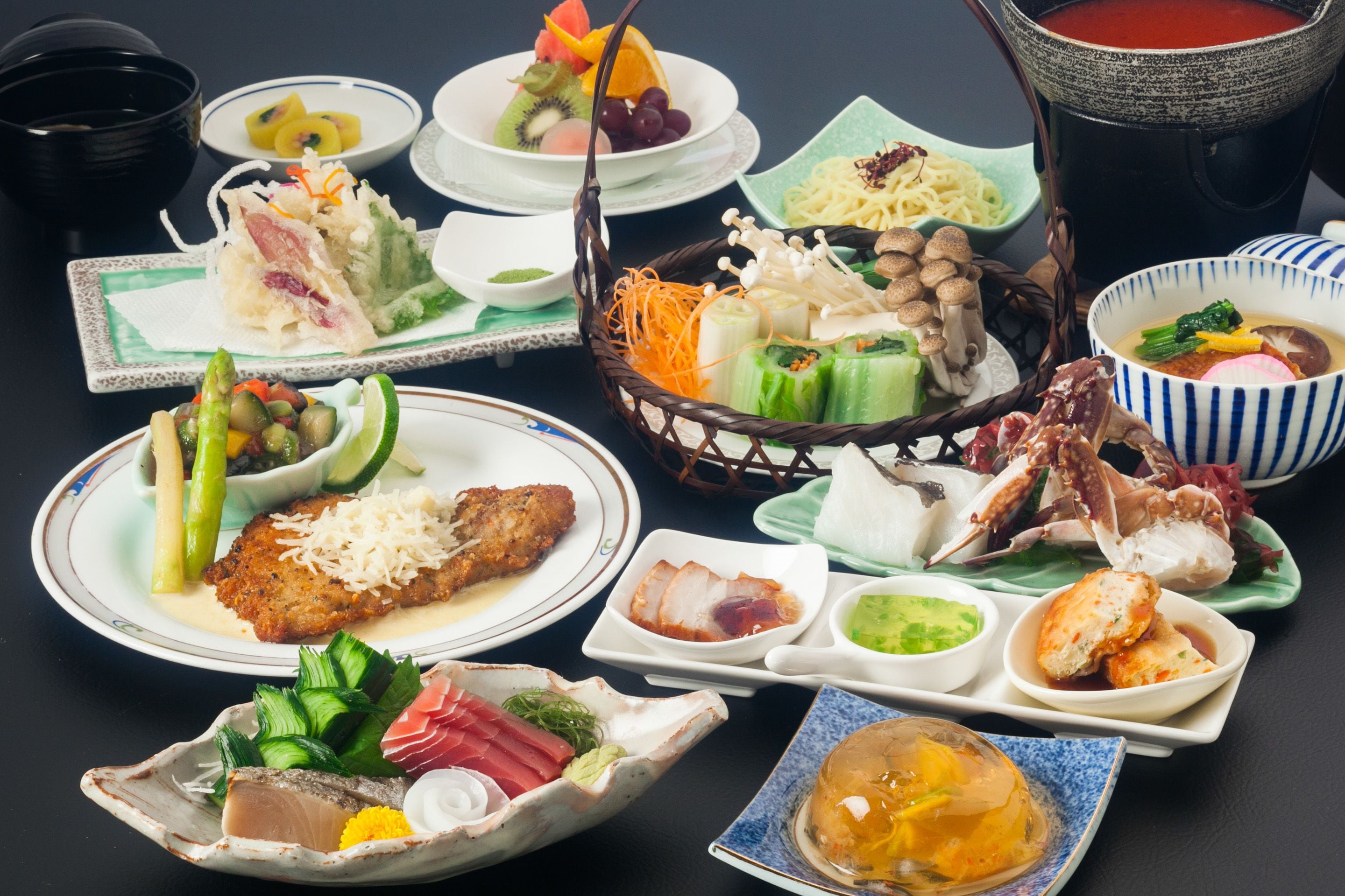 A variety of dishes on a table, including seafood, vegetables, and a pot of soup.
