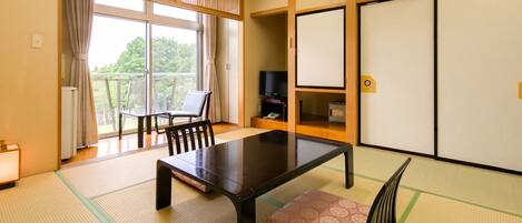 A traditional Japanese-style room with tatami flooring, a low table, and a sliding door.