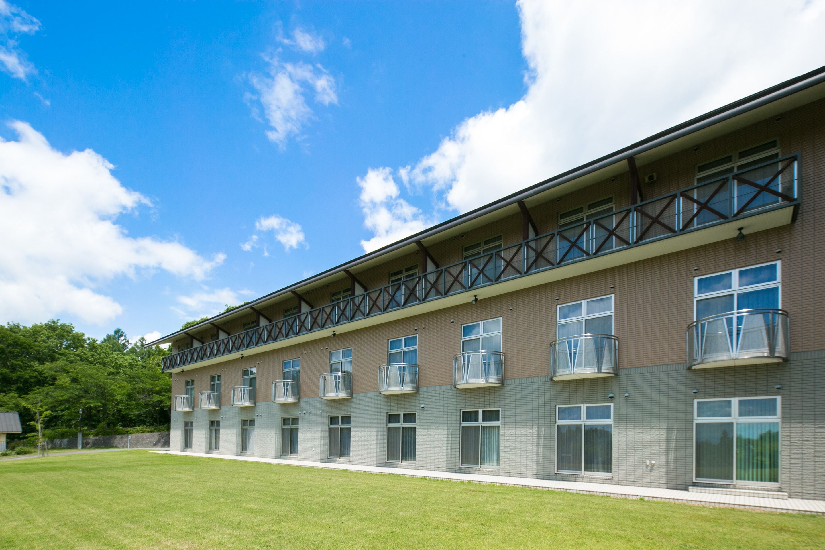 A multi-story building with a flat roof, large windows, and balconies.