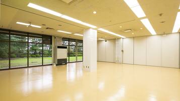 A spacious, well-lit room with large windows, a polished floor, and a minimalist design.