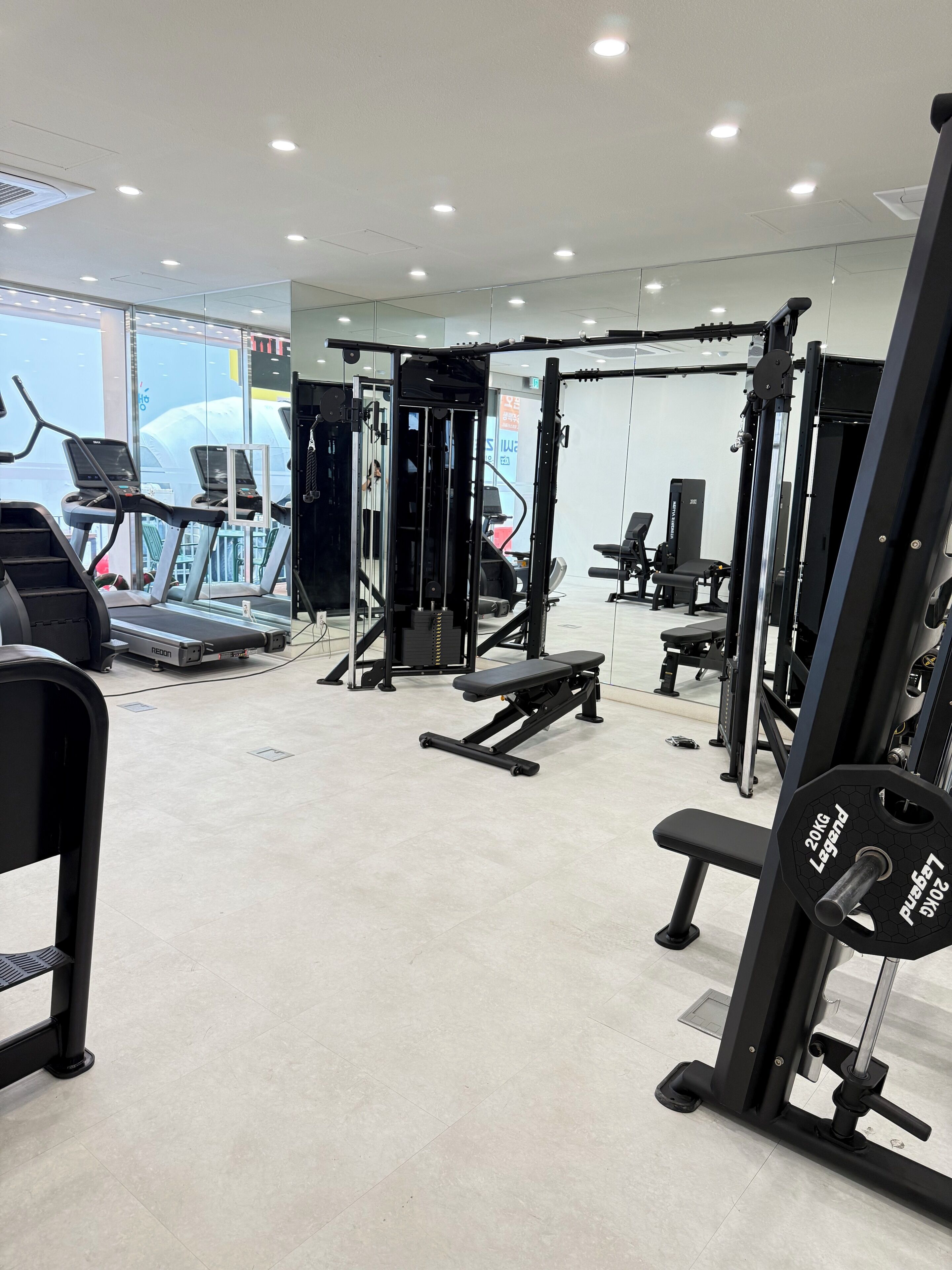 A gym with treadmills, weight machines, and benches.