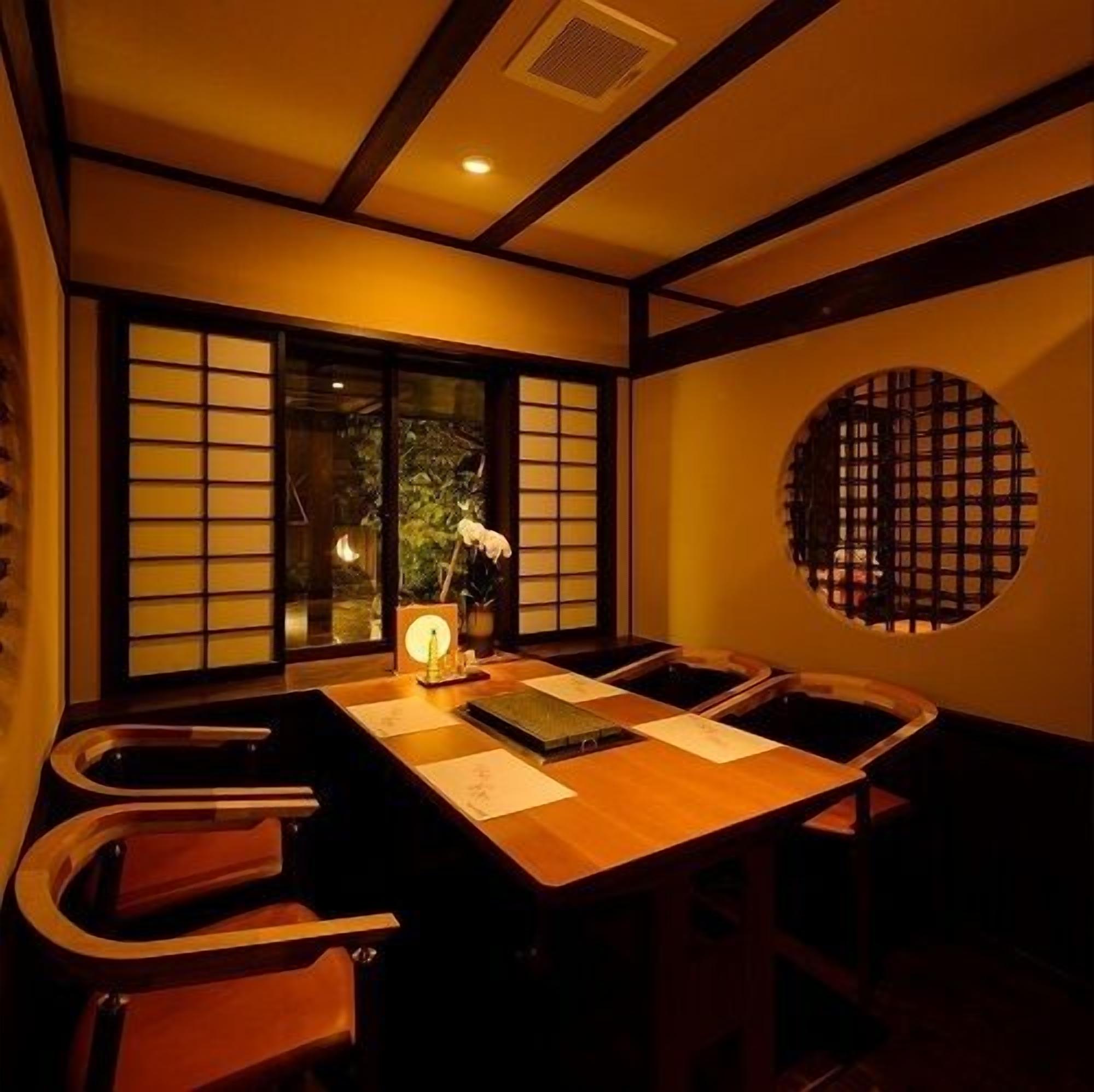 A traditional Japanese room with tatami flooring, a low table, and sliding doors.
