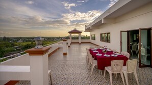 A rooftop terrace with a dining setup, a gazebo, and a view of the surrounding landscape. - Doungta Anda Hotel (Krabi)