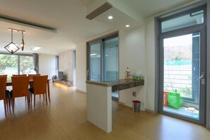 A modern kitchen with a marble countertop, wooden chairs, and a dining area with a table and chairs.