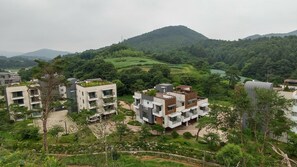 Zona residencial con edificios modernos, espacios verdes y un paisaje montañoso al fondo.