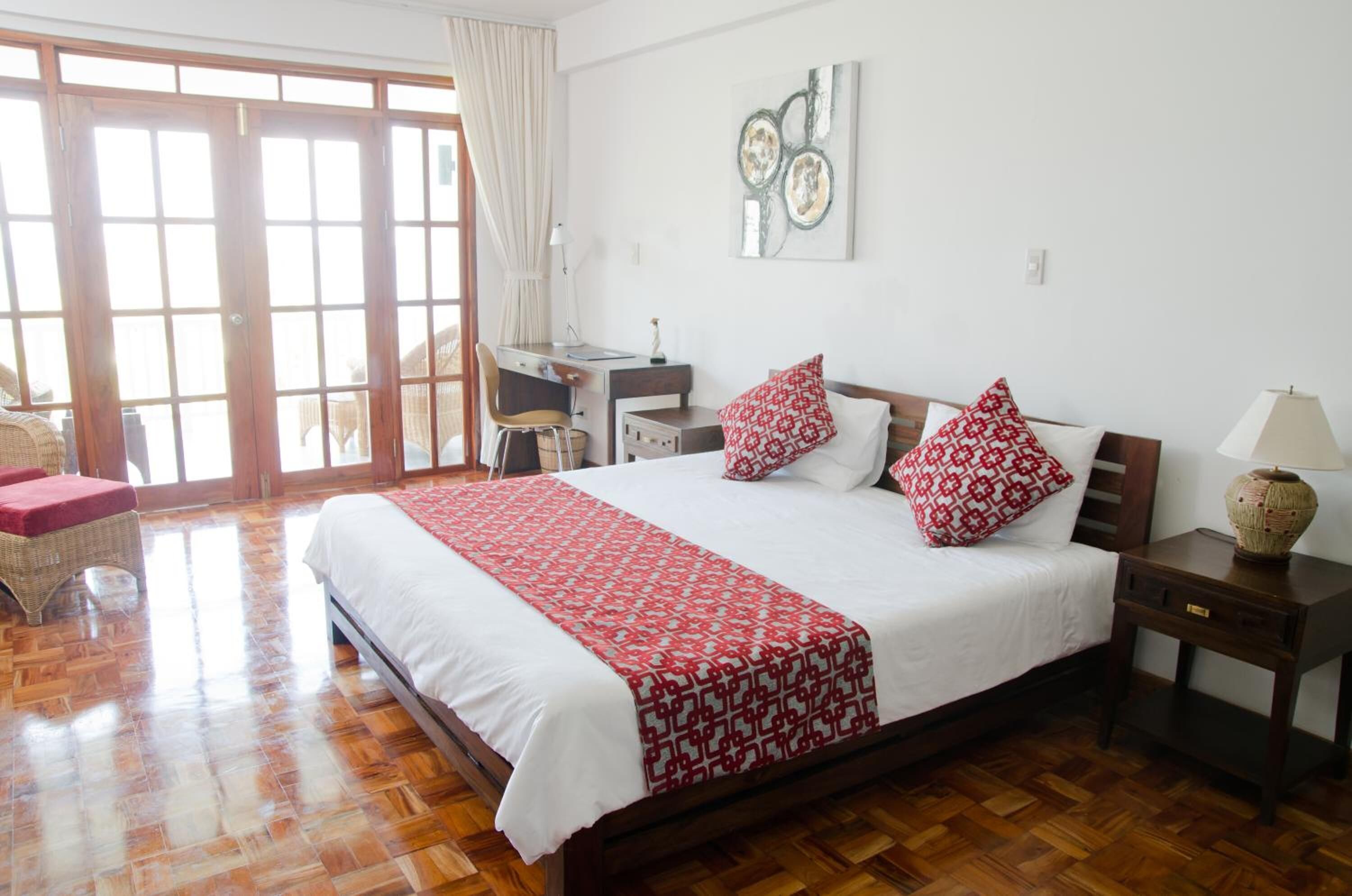 Un dormitorio con una cama grande, un escritorio y una silla.