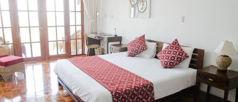 Un dormitorio con una cama grande, un escritorio y una silla.