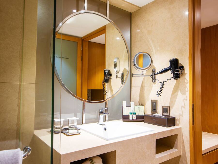 A modern bathroom with a large mirror, a hairdryer, and a sink.