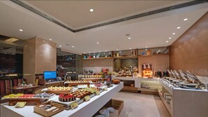 A buffet area with various food items and a laptop on a table. - The Fern Mumbai, Goregaon, Series by Marriott (Mumbai)