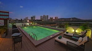 A rooftop pool area with lounge chairs and a city skyline view. - The Fern Mumbai, Goregaon, Series by Marriott (Mumbai)